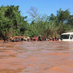 Crossing a much bigger flooded river with the help of an entire village. (© Christian Peeters)