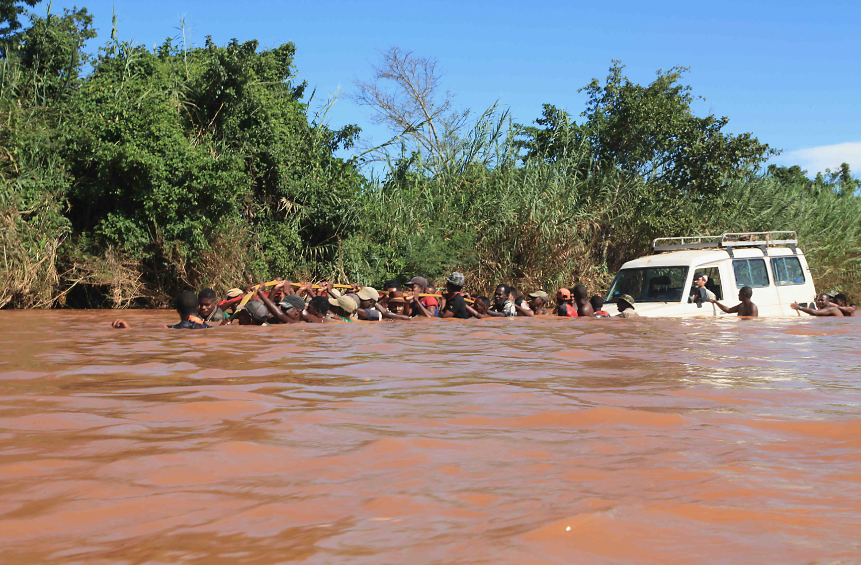 Crossing a much bigger flooded river with the help of an entire village. (© Christian Peeters)